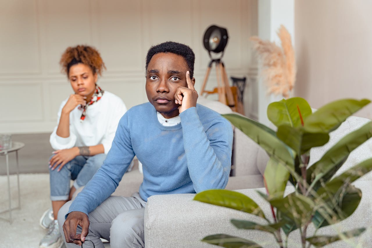 creative-03 Two individuals contemplating during a therapy session, sitting in a modern room.